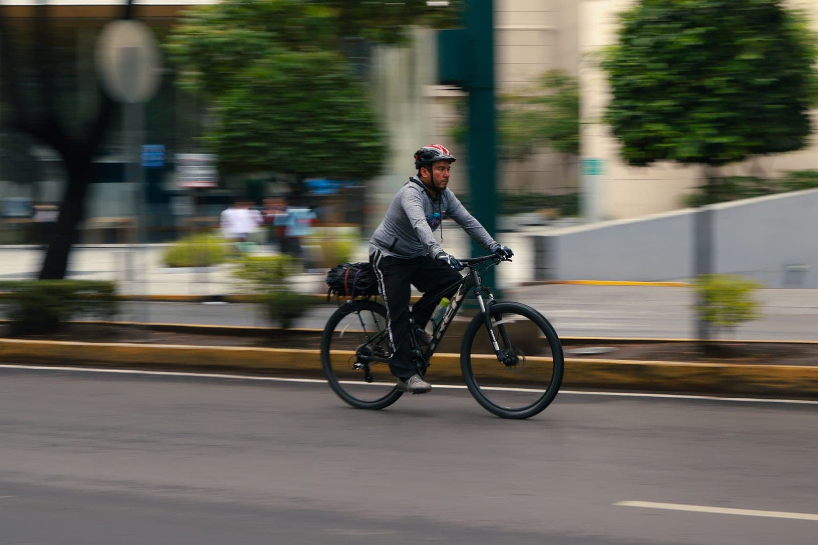A commuter riding a bike through a bright city street