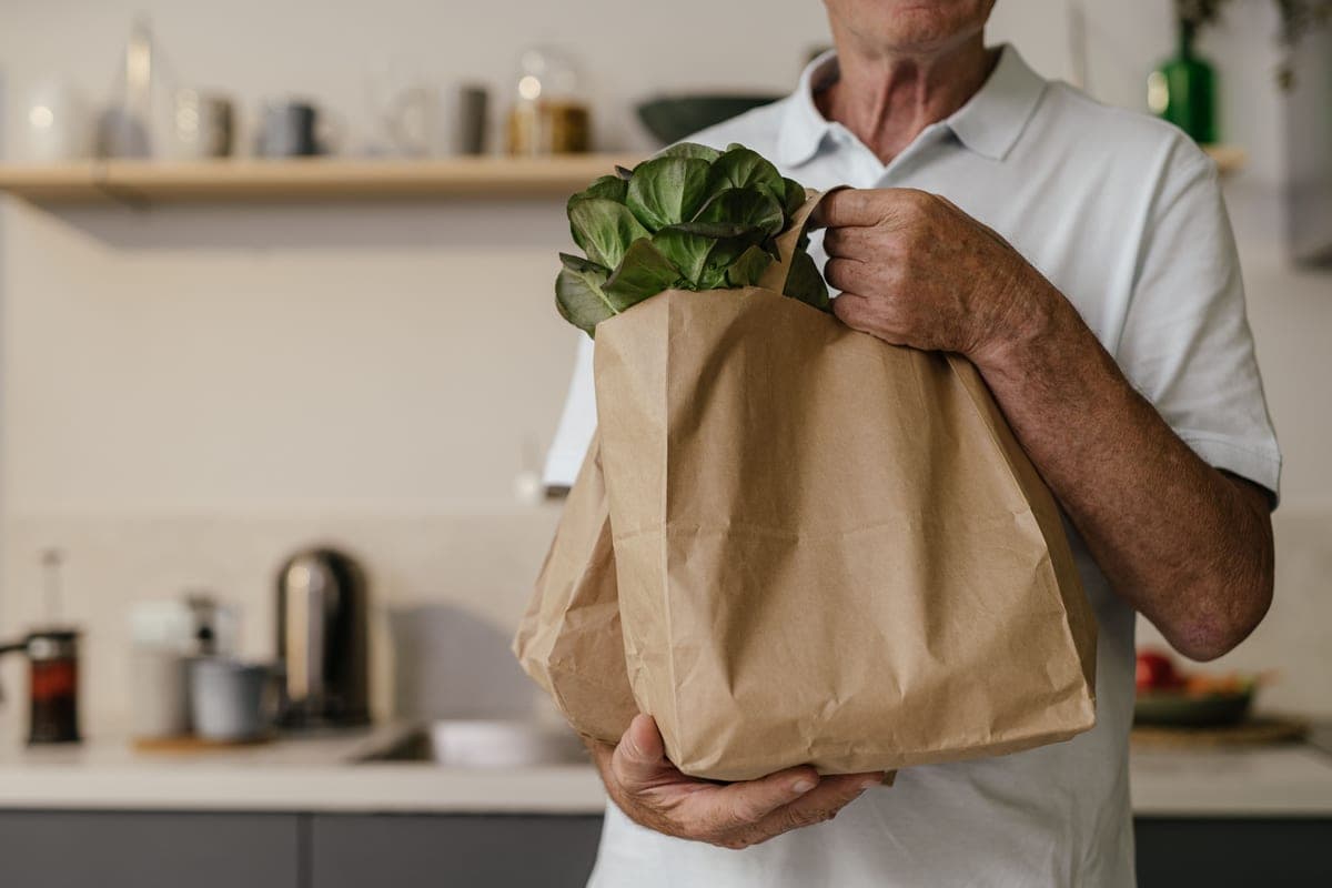 A paper bag of fresh groceries to carry home by bike