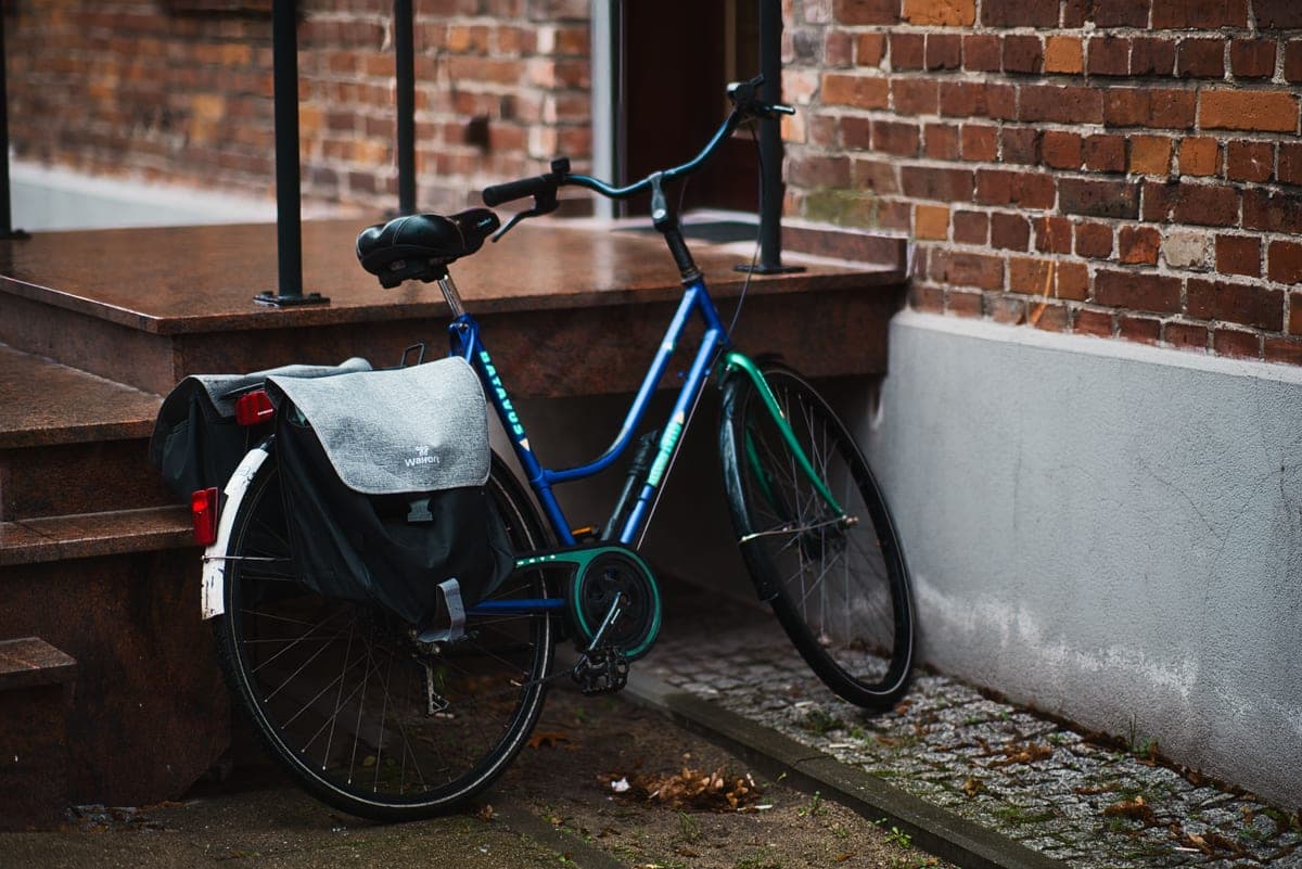 An urban commuter bicycle leaning against a brick wall