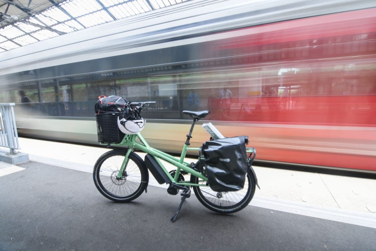 A cargo bike with a rack parked at a station