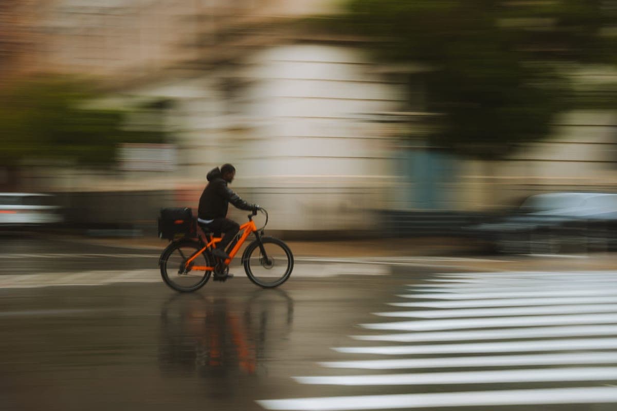 A cyclist commuting through the city in the rain